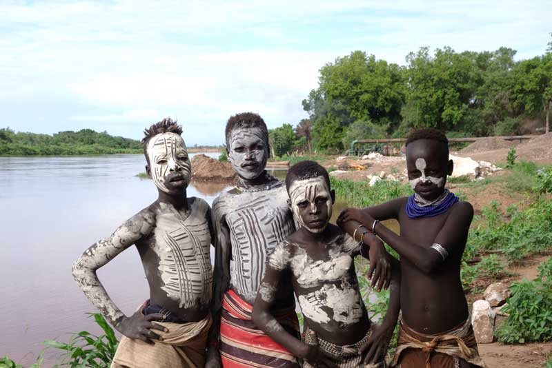 Local children with Omo river and water extraction pipe Copyright: Jane Baldwin