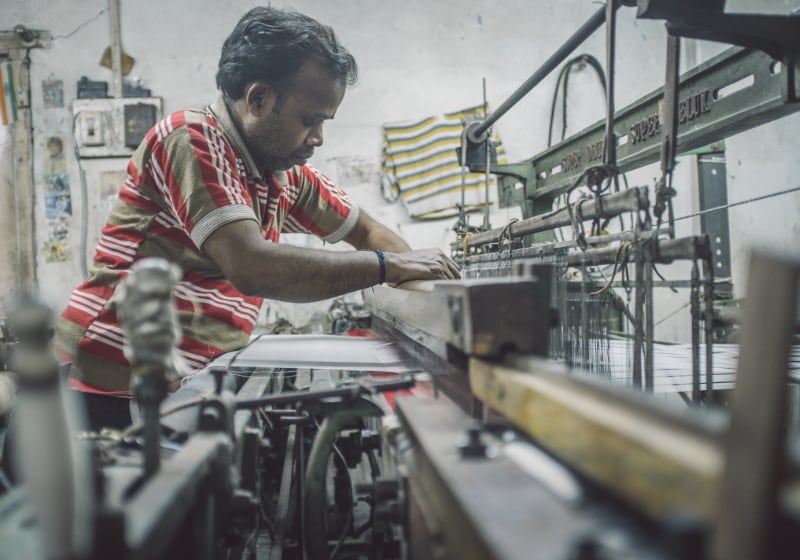 Indi.an textile worker struggles in extreme heat in a factory.